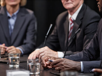Hands of Black Man Sitting at Table while Speaking at Political Meeting